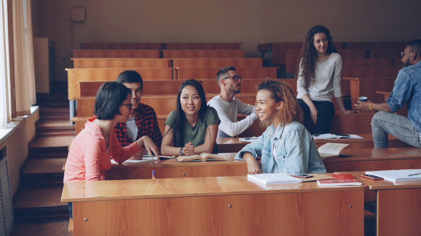 Young adults collaborating in a university lecture hall.